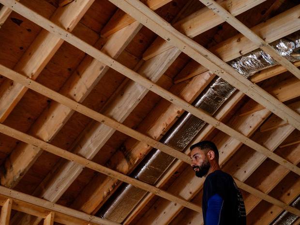 A Hero Tech technician inspecting a large ductwork run in an attic